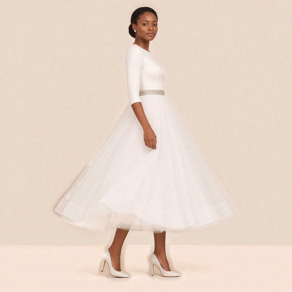 Femme de profil dans la robe de mariée mi-longue, jupe en tulle déployée