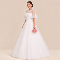 Robe de mariée princesse vue de trois quarts : cape en tulle transparent et jupe ample