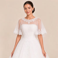 Détail de la cape en tulle à col rond en dentelle et du buste bustier en dentelle