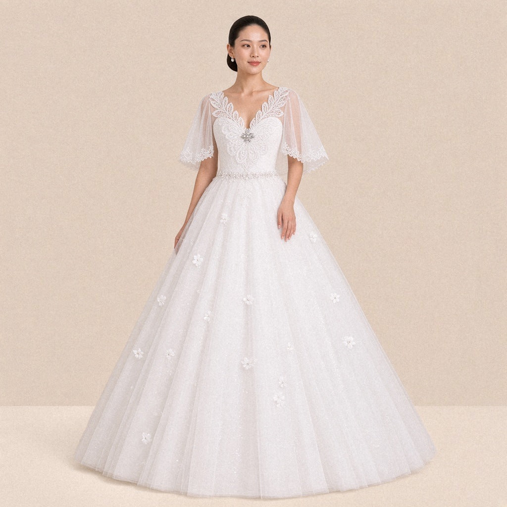 Robe de mariée princesse blanche col V en guipure et manches en tulle, portée de face
