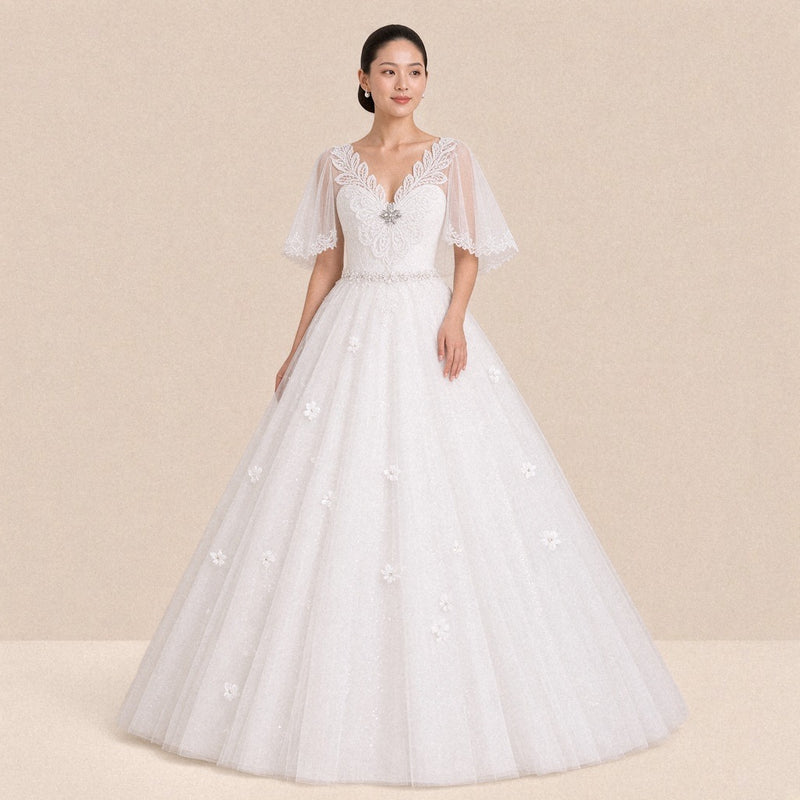 Robe de mariée princesse blanche col V en guipure et manches en tulle, portée de face