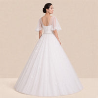 Dos de la robe de mariée : empiècement en tulle transparent en V et laçage corset