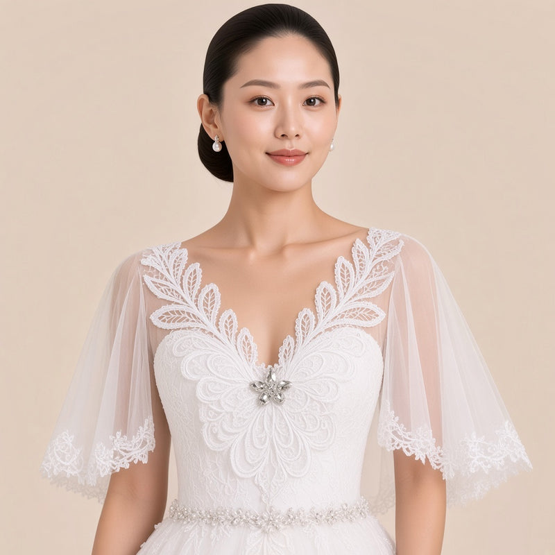 Détail du col V en guipure, de la broche strass et des manches en tulle