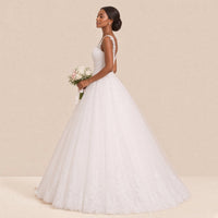 Robe de mariée princesse vue de profil, volume de la jupe en tulle et bordure de dentelle