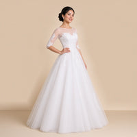 Robe de mariée princesse en dentelle et tulle vue de trois quarts, jupe ample au ras du sol