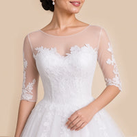Gros plan du col rond en tulle transparent et du corsage en dentelle au décolleté en cœur