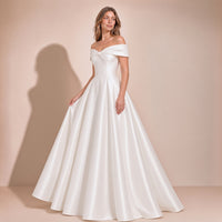 Femme de trois quarts dans la robe de mariée princesse en satin, jupe ample plissée