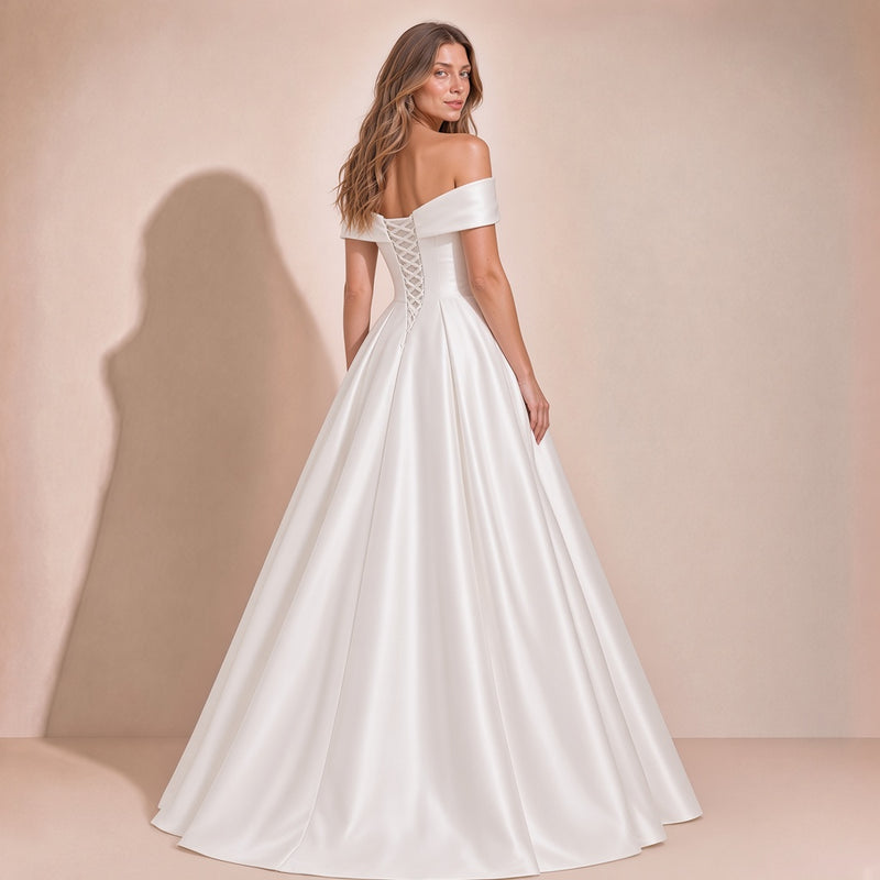 Femme de dos dans la robe de mariée en satin : dos à lacets et jupe ample