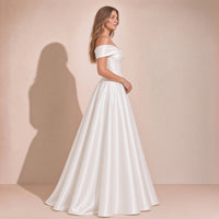 Femme de profil dans la robe de mariée princesse en satin épaules dénudées