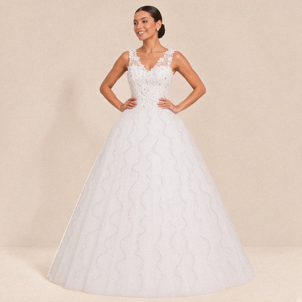 Robe de mariée princesse blanche col V à fleurs en relief, portée de face, mains à la taille