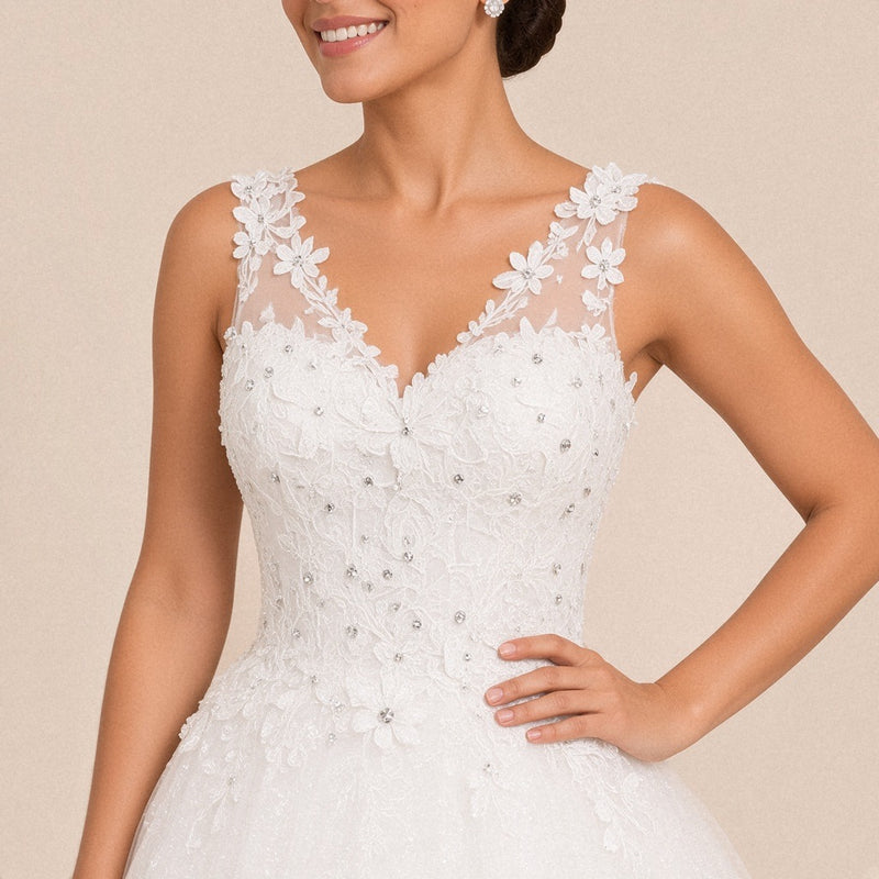 Détail du col V, des bretelles en tulle bordées de fleurs à strass et du buste en dentelle