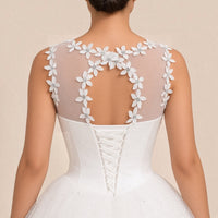 Détail du dos : guirlande de fleurs en relief, ouverture ovale et laçage corset en ruban satiné