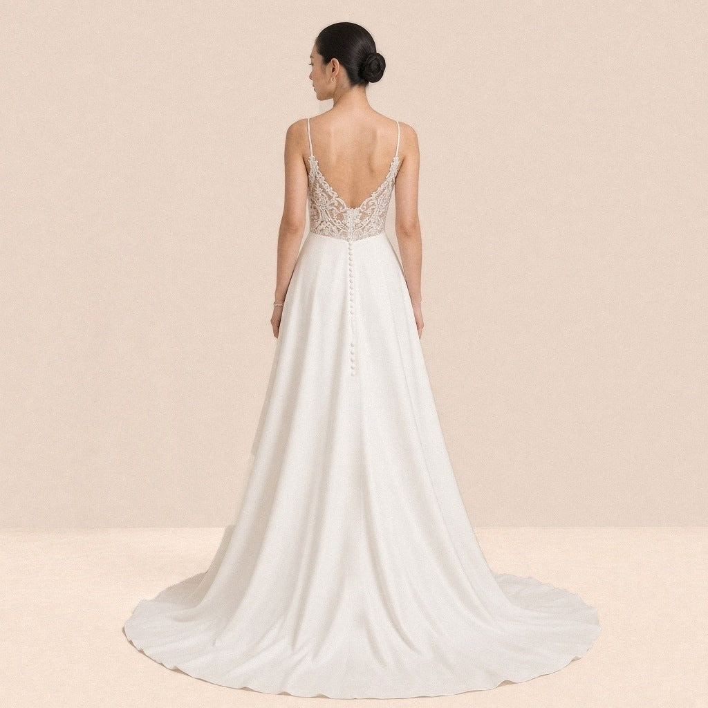 Robe de mariée satinée vue de dos, dos en dentelle orné de boutons et longue traîne