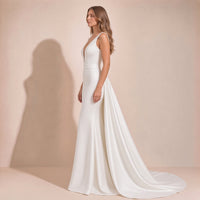 Femme de profil dans la robe de mariée sirène : ceinture large et pan de satin fixé à l’arrière de la taille