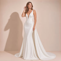 Femme en pose naturelle dans la robe de mariée en satin, traîne étalée