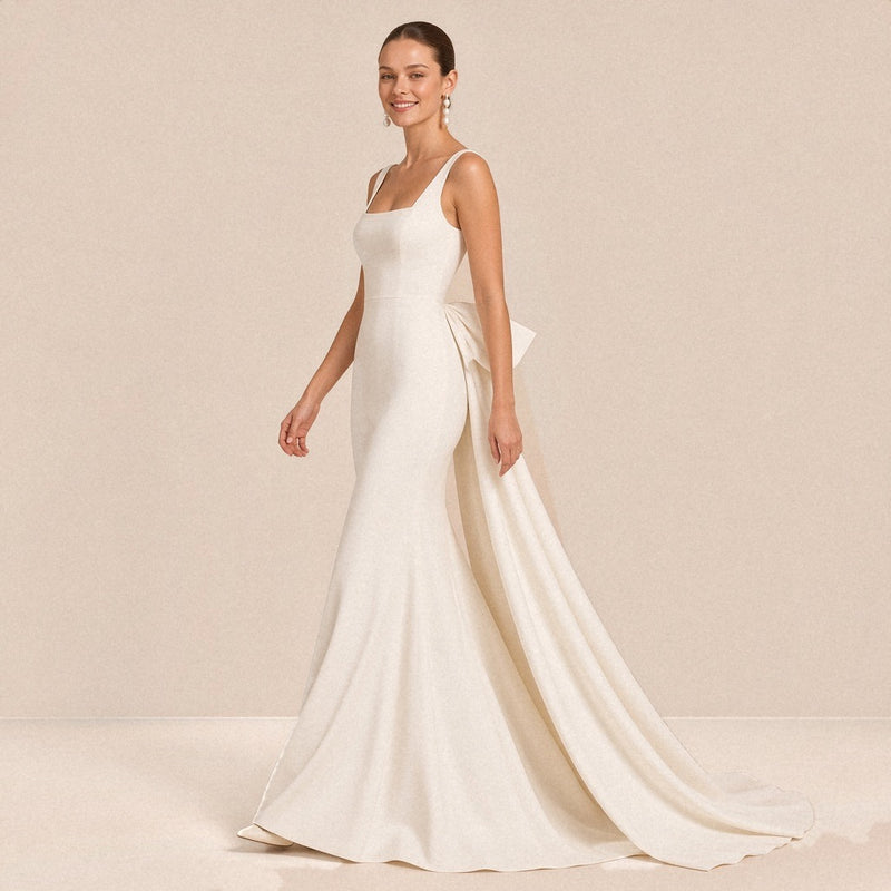 Robe de mariée sirène satinée blanche portée en marchant, vue de trois quarts avec traîne