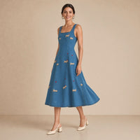 Robe midi en jean bleu denim brodée de petits teckels, portée en marchant de trois quarts