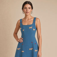 Robe midi en jean bleu denim brodée de petits teckels, détail des broderies, portée de trois quarts