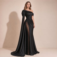 Femme de trois quarts dans la robe de soirée noire à épaules dénudées et broderies perlées