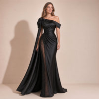 Femme en pose naturelle dans la robe de soirée sirène noire avec pan de satin et traîne