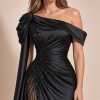 Robe noire portée, détail de l’encolure épaules dénudées, de l’épaule drapée perlée et de la taille froncée