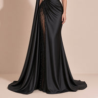 Robe noire portée, détail de l’empiècement brodé de perles sur la jupe et de la traîne en satin