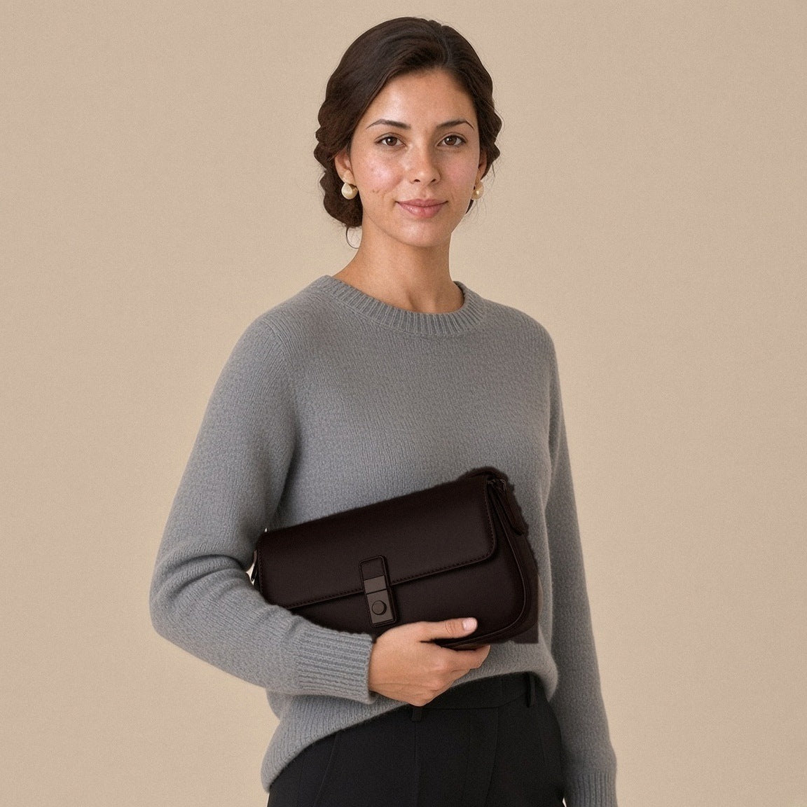 Sac baguette en similicuir café tenu sous le bras, vue de face, sur une femme