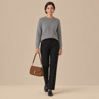 Sac baguette en similicuir caramel tenu à la main, vue en pied, sur une femme