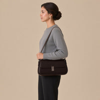 Sac baguette en similicuir café porté à l’épaule, vue de profil, sur une femme