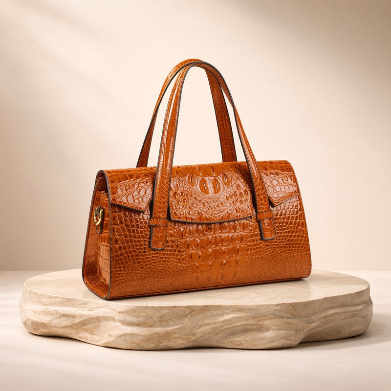 Sac Boston effet croco orange, posé sur un socle en pierre, vue produit