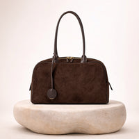 Sac bowling en daim matelassé SAKIWE, coloris café, sur socle en pierre
