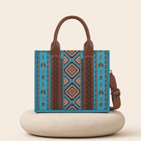 Sac cabas motif aztèque SAKIWE, coloris Turquoise – présenté sur un socle en pierre crème