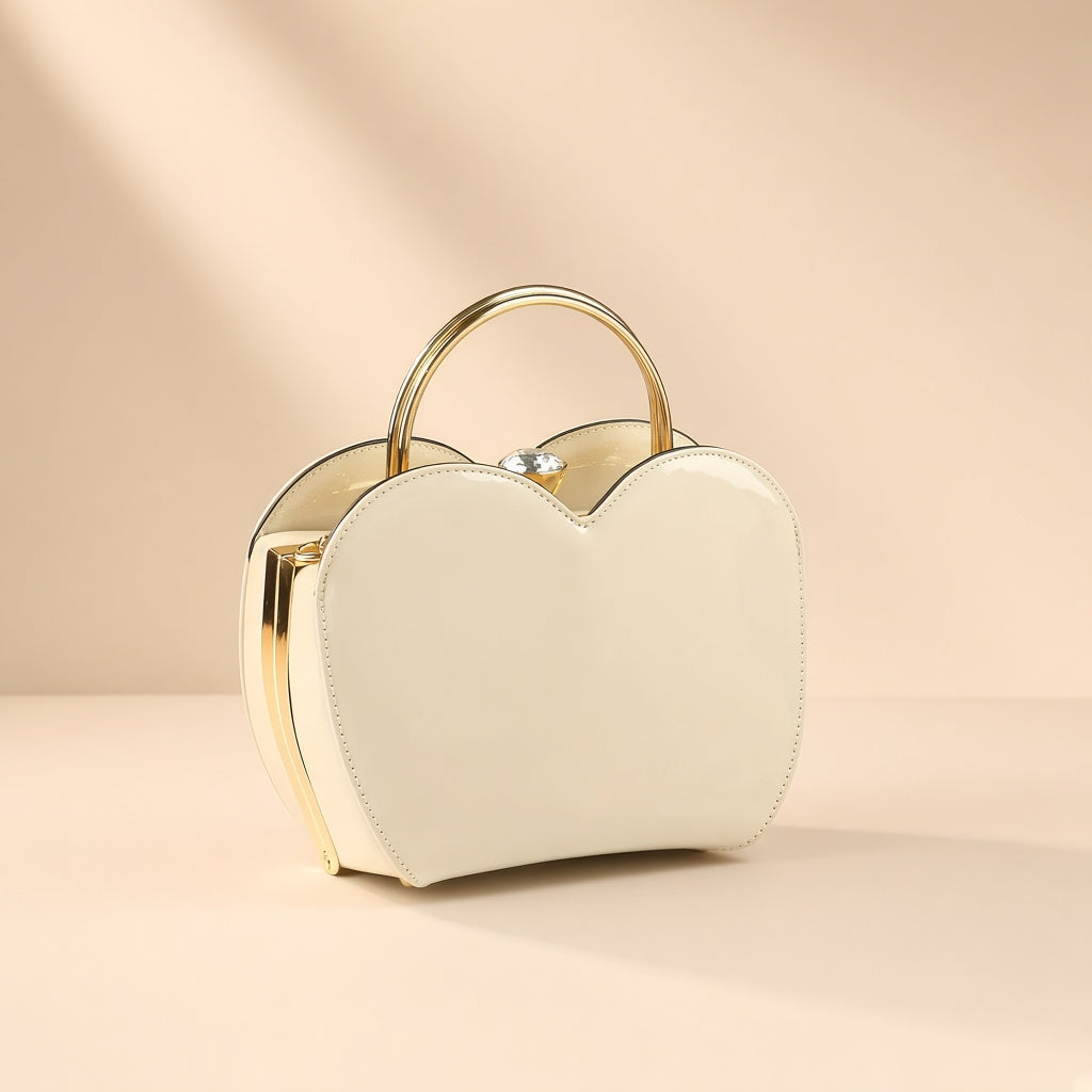 Sac coquille en cuir verni blanc cassé à fermoir bijou, vue de trois quarts sur fond beige