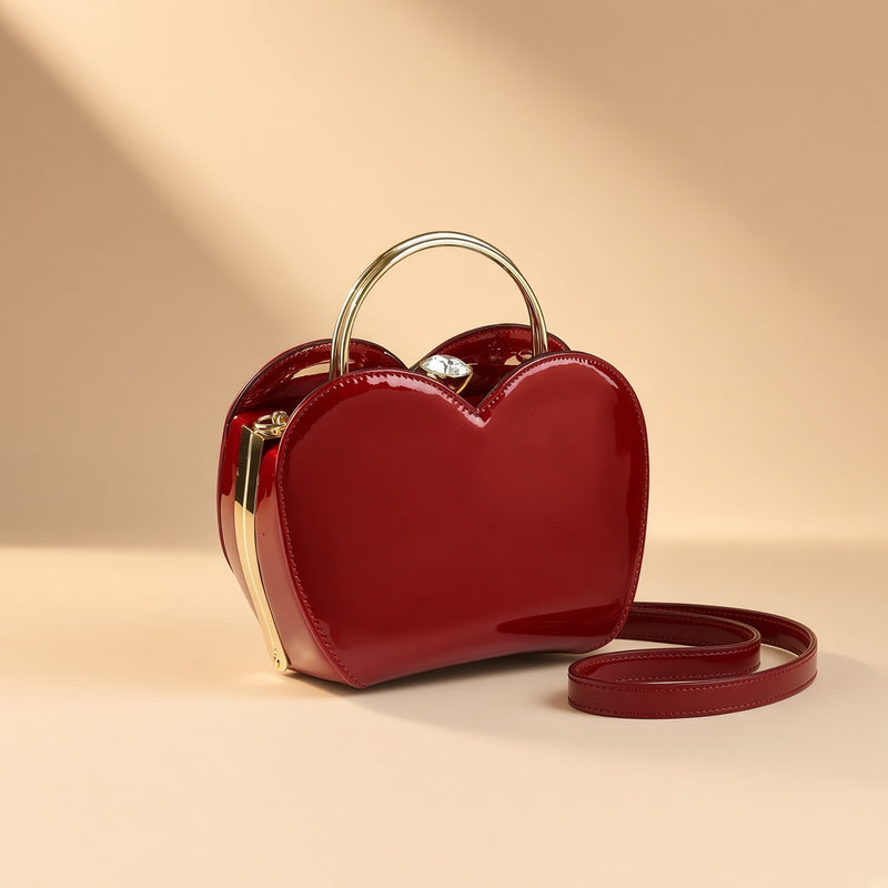 Sac coquille en cuir verni bordeaux à fermoir bijou, vue de trois quarts sur fond beige