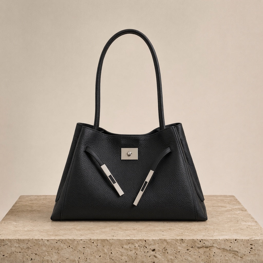 Sac porté épaule en cuir Togo SAKIWE noir posé sur un socle en pierre