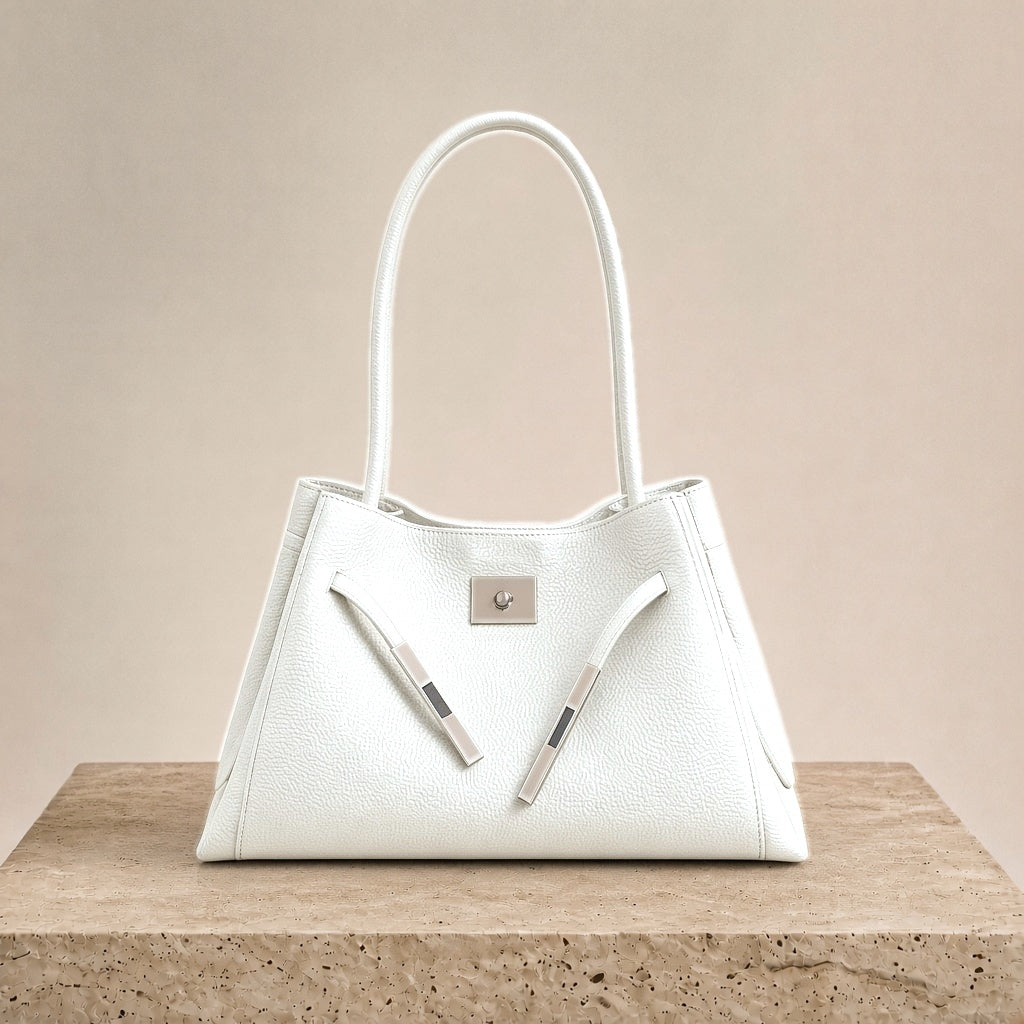 Sac porté épaule en cuir Togo SAKIWE blanc craie posé sur un socle en pierre