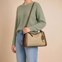 Sac porté épaule oreiller en cuir grainé beige et cognac, porté à l’épaule, vue rapprochée