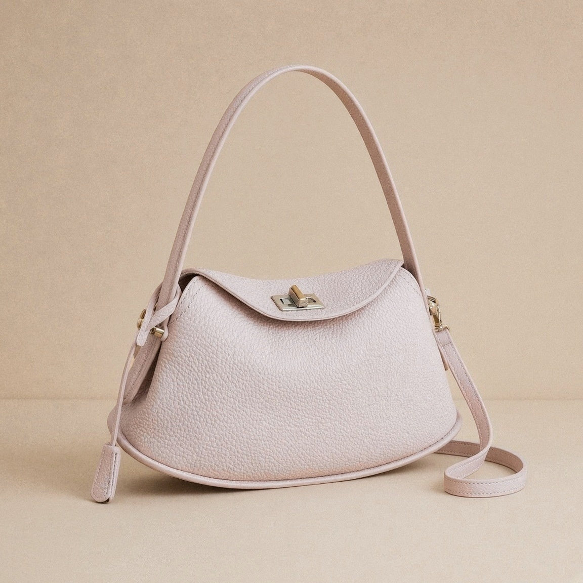 Sac oreiller en cuir grainé SAKIWE rose poudré seul, vue de trois quarts avec sa bandoulière