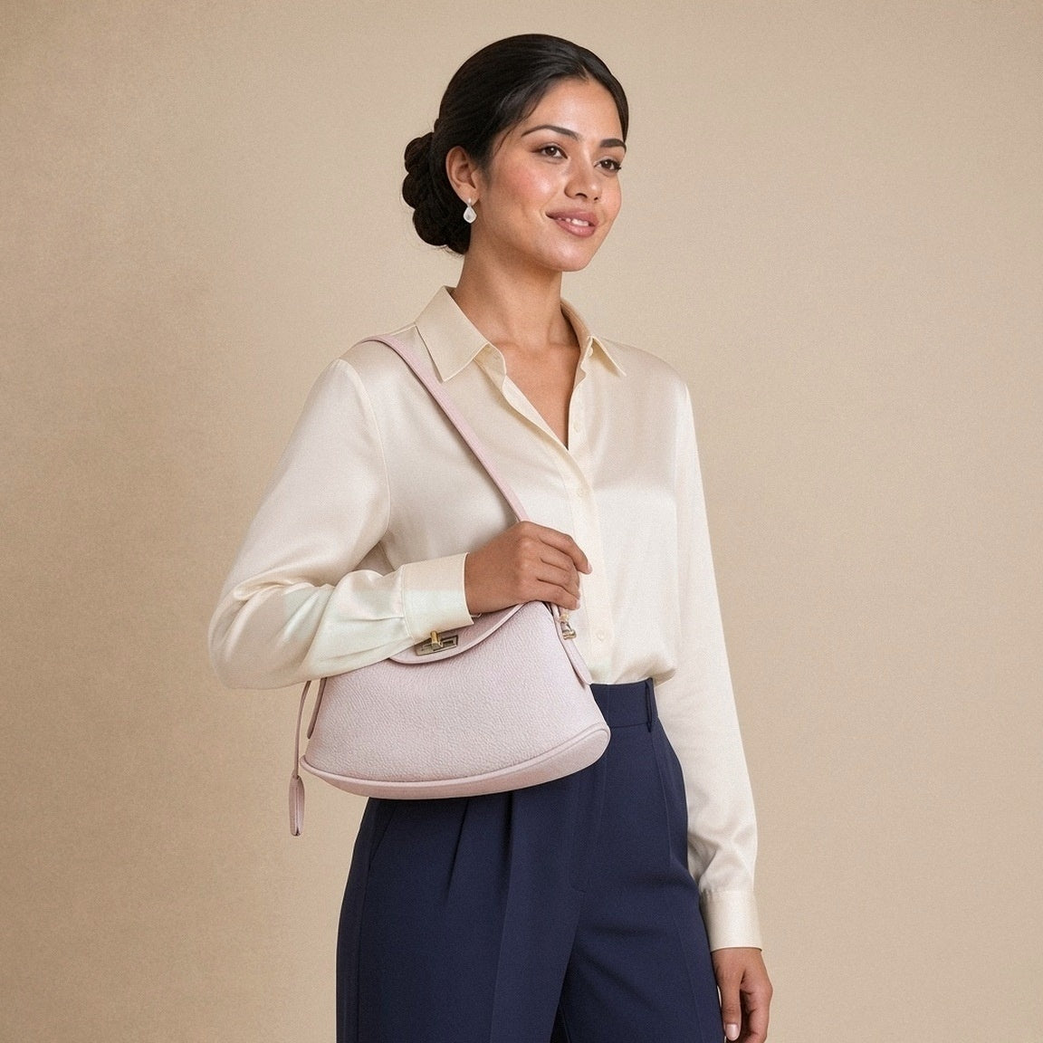 Sac oreiller en cuir grainé SAKIWE rose poudré porté à l’épaule, sous le bras