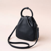 Sac seau froncé en cuir gris fer à anse anneau, vu de trois quarts avec sa bandoulière