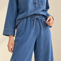 Détail de la taille élastique du pantalon en jean bleu avec lien à nouer.