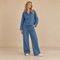 Ensemble en jean bleu porté de face, avec haut à manches longues et pantalon large à taille élastique.