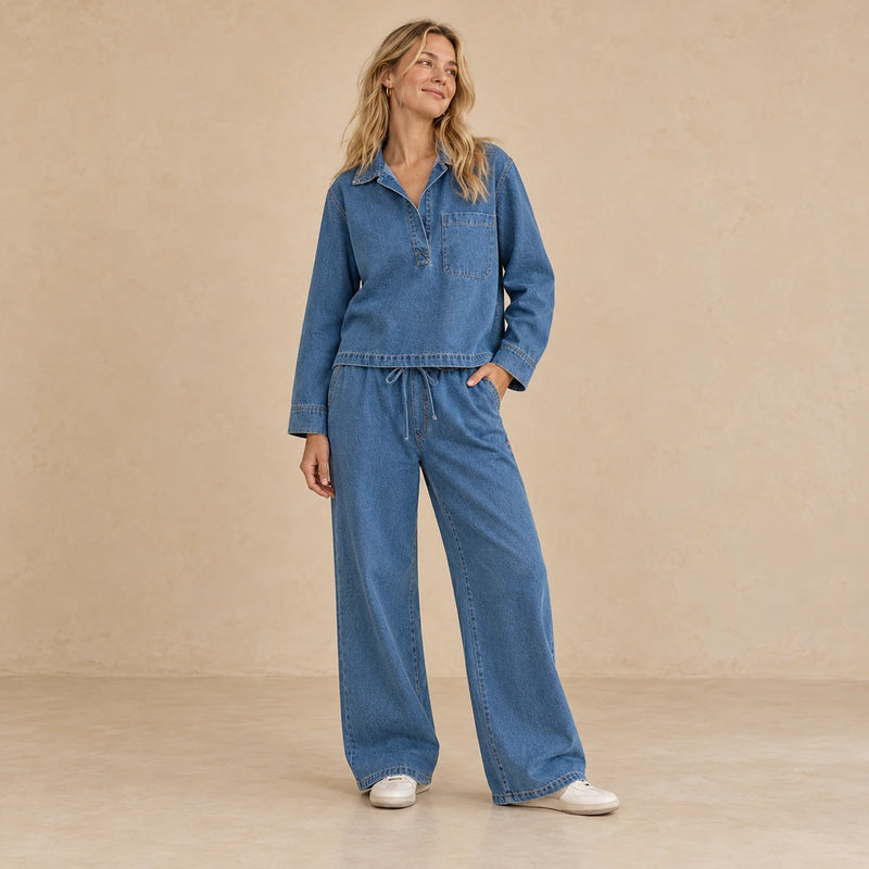 Ensemble en jean bleu porté de face, avec haut à manches longues et pantalon large à taille élastique.