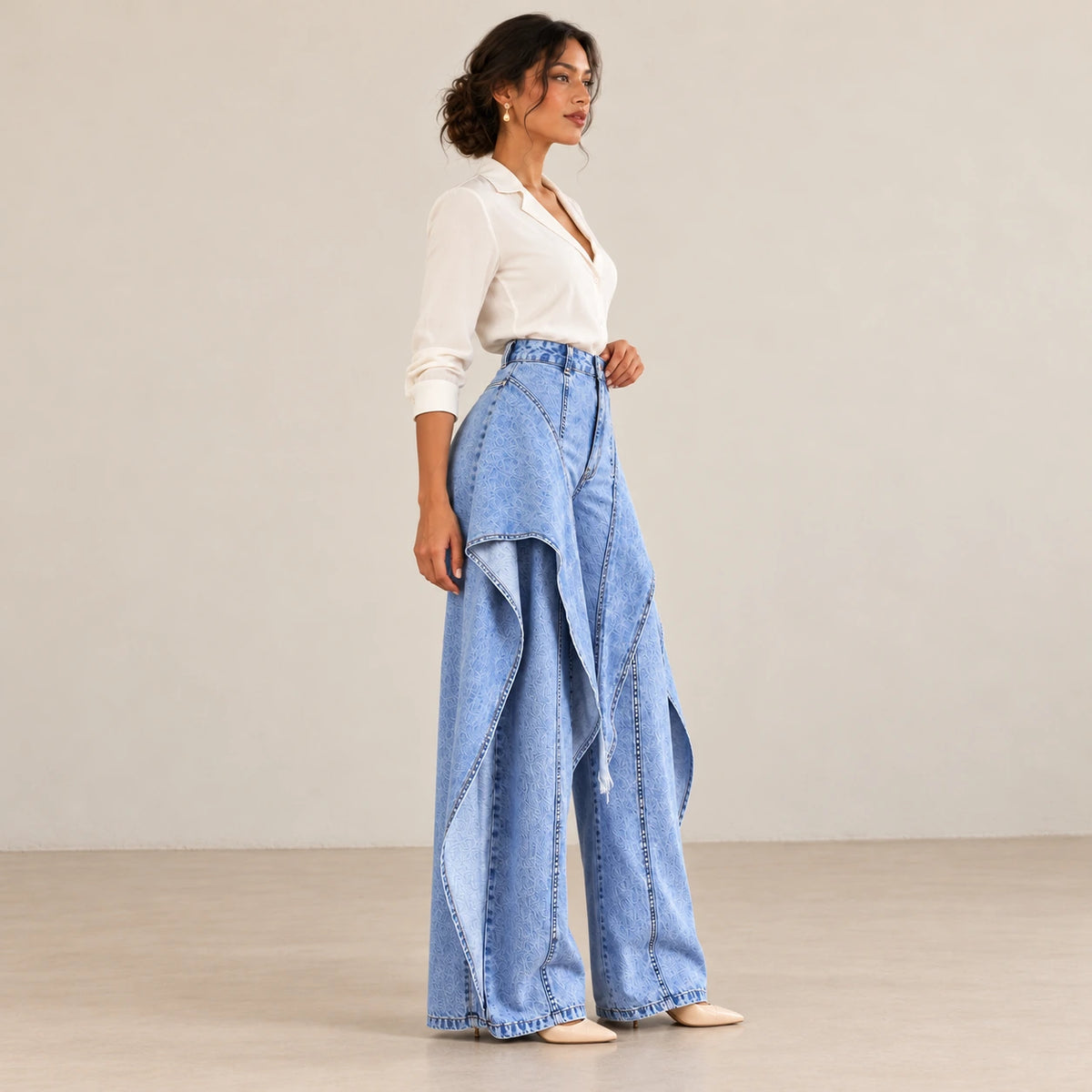 Vue de profil du jean large bleu à jambes amples et panneaux drapés.