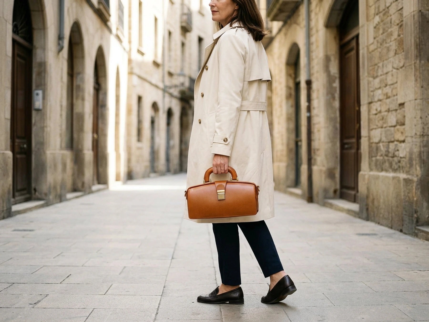 Femme portant un sac a main camel SAKIWE dans une rue lumineuse