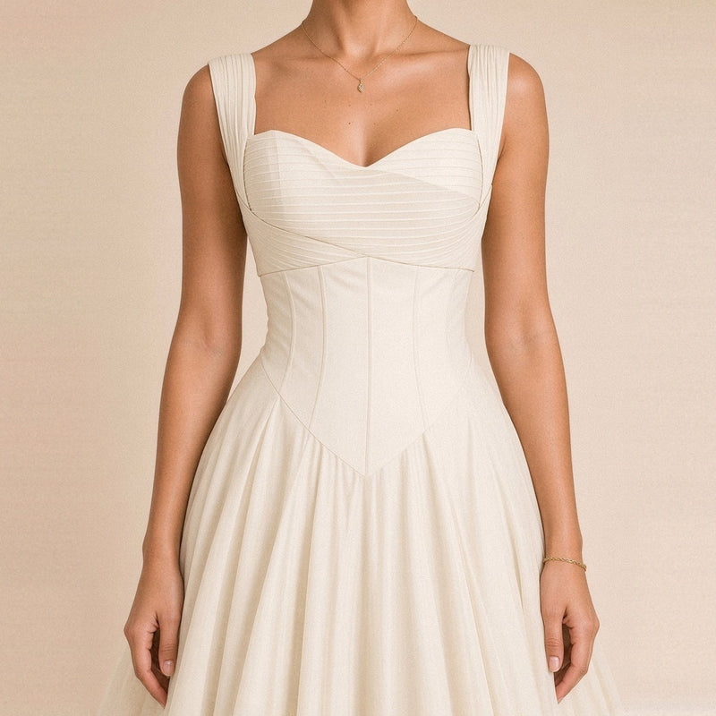 Robe midi corsetée SAKIWE blanche portée, en gros plan sur le décolleté cœur et la taille corsetée