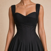 Robe midi corsetée SAKIWE noire portée, en gros plan sur le décolleté cœur et la taille corsetée
