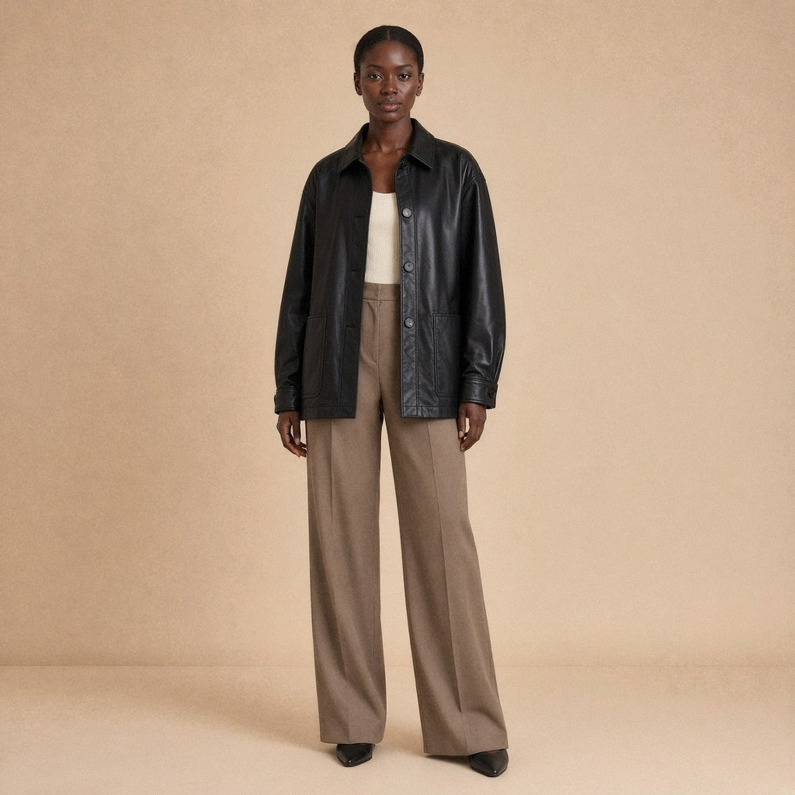 Surchemise oversize en cuir de mouton noir SAKIWE portée boutonnée de face par une mannequin