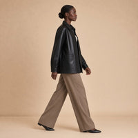 Surchemise oversize en cuir de mouton noir SAKIWE portée en marchant, vue de profil
