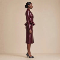 Tailleur effet cuir, veste zippée à basque et jupe crayon fendue, bordeaux profond, porté de profil